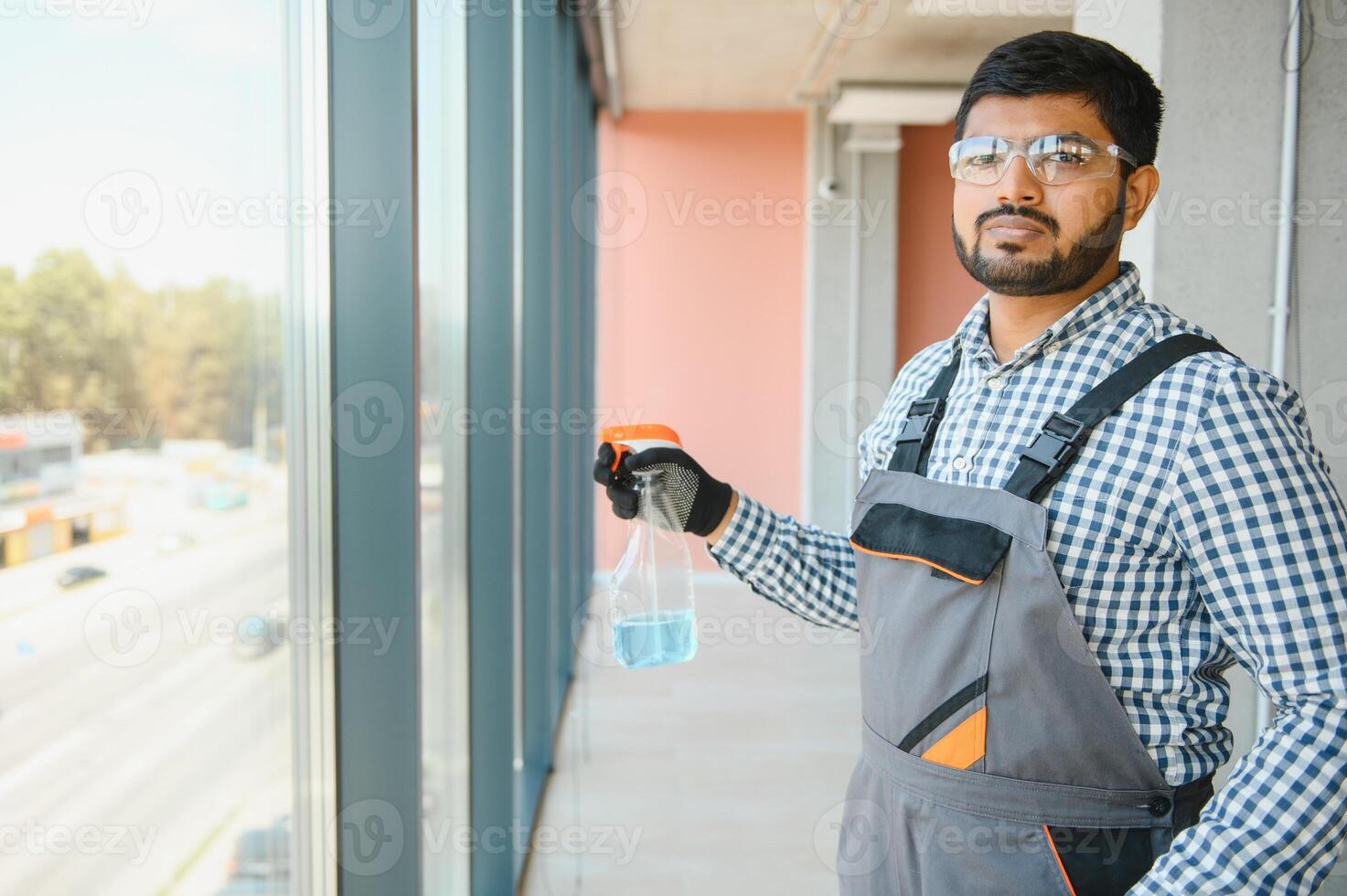 Male professional cleaning service worker cleans the windows and shop windows of a store with special equipment photo