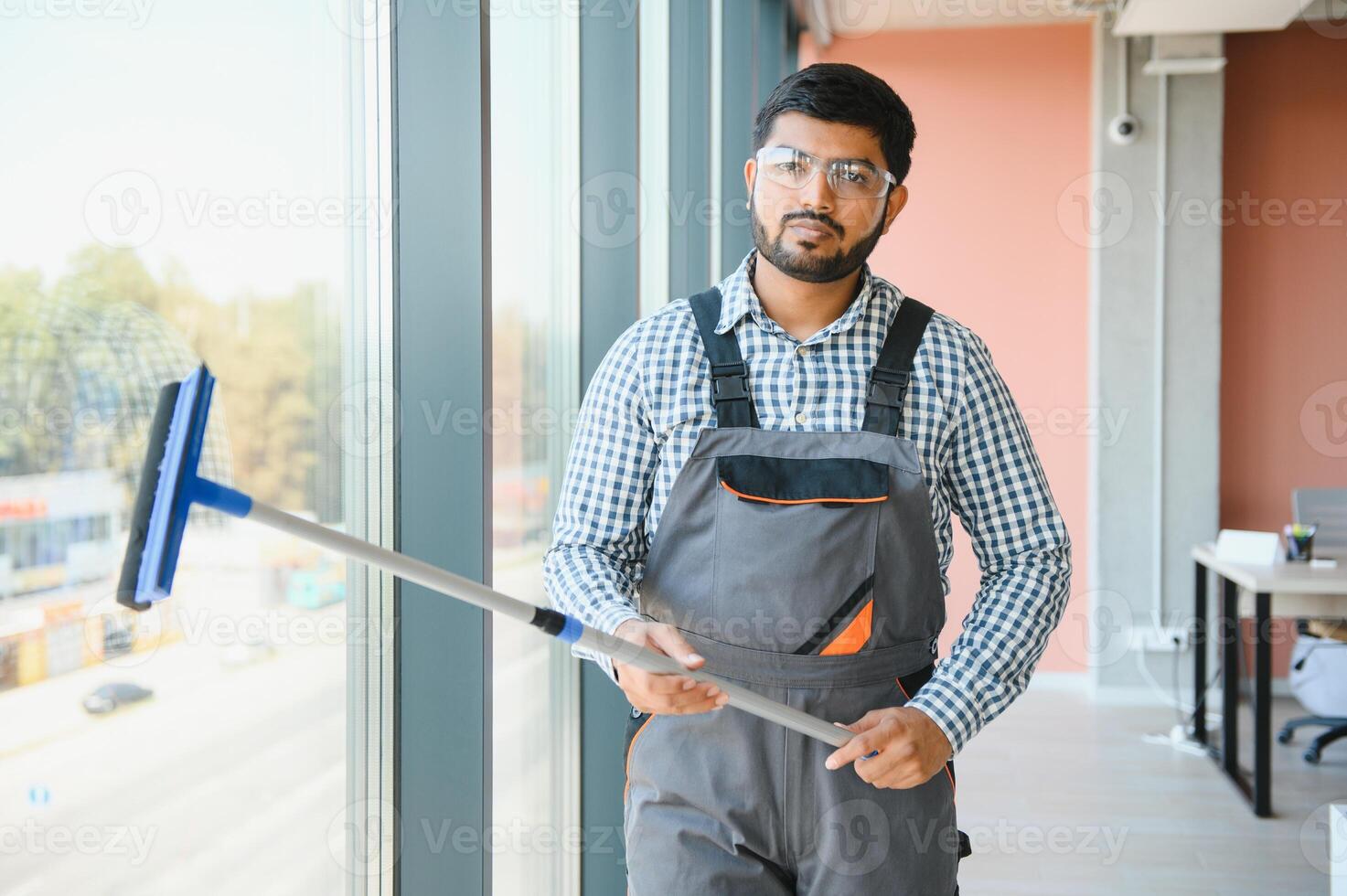 Male professional cleaning service worker cleans the windows and shop windows of a store with special equipment photo