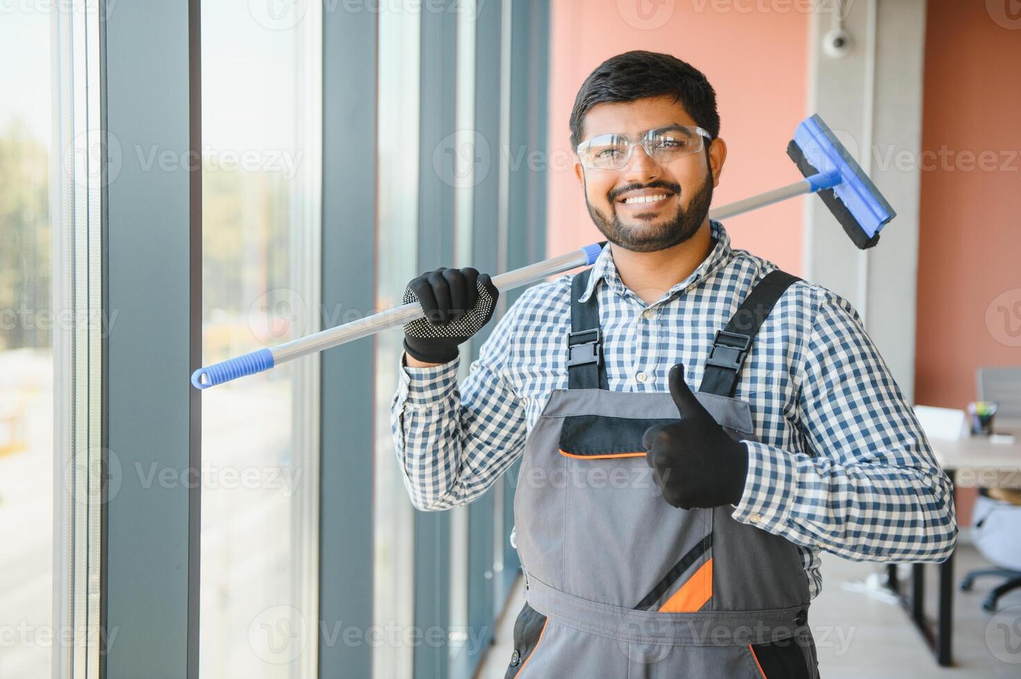 Male professional cleaning service worker cleans the windows and shop windows of a store with special equipment photo