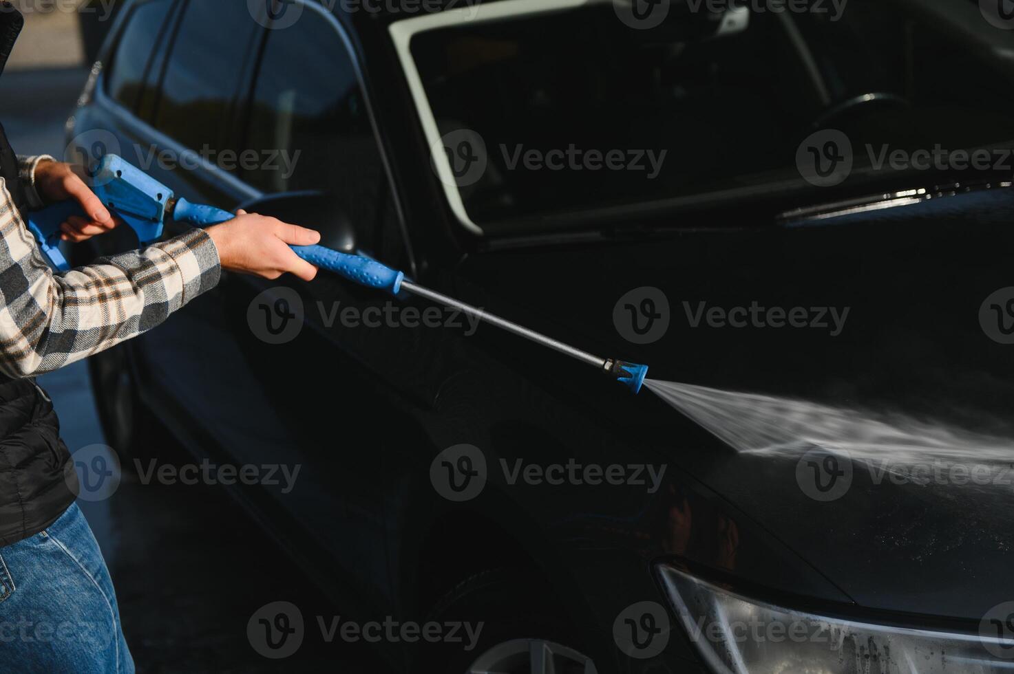 A man washes his car at a car wash. Self service car wash. photo