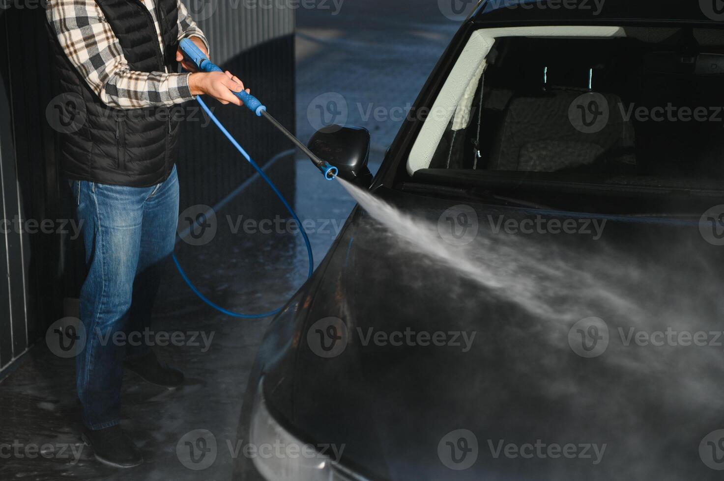 A man washes his car at a car wash. Self service car wash. photo