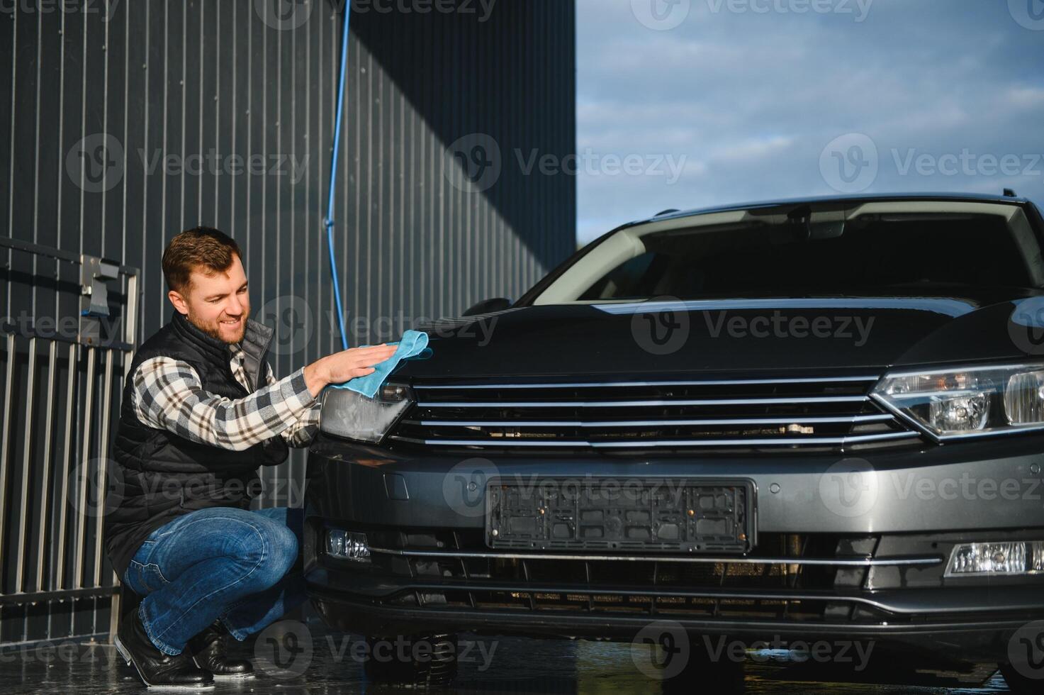 Male wiping car with microfiber cloth closeup. Car wash concept photo