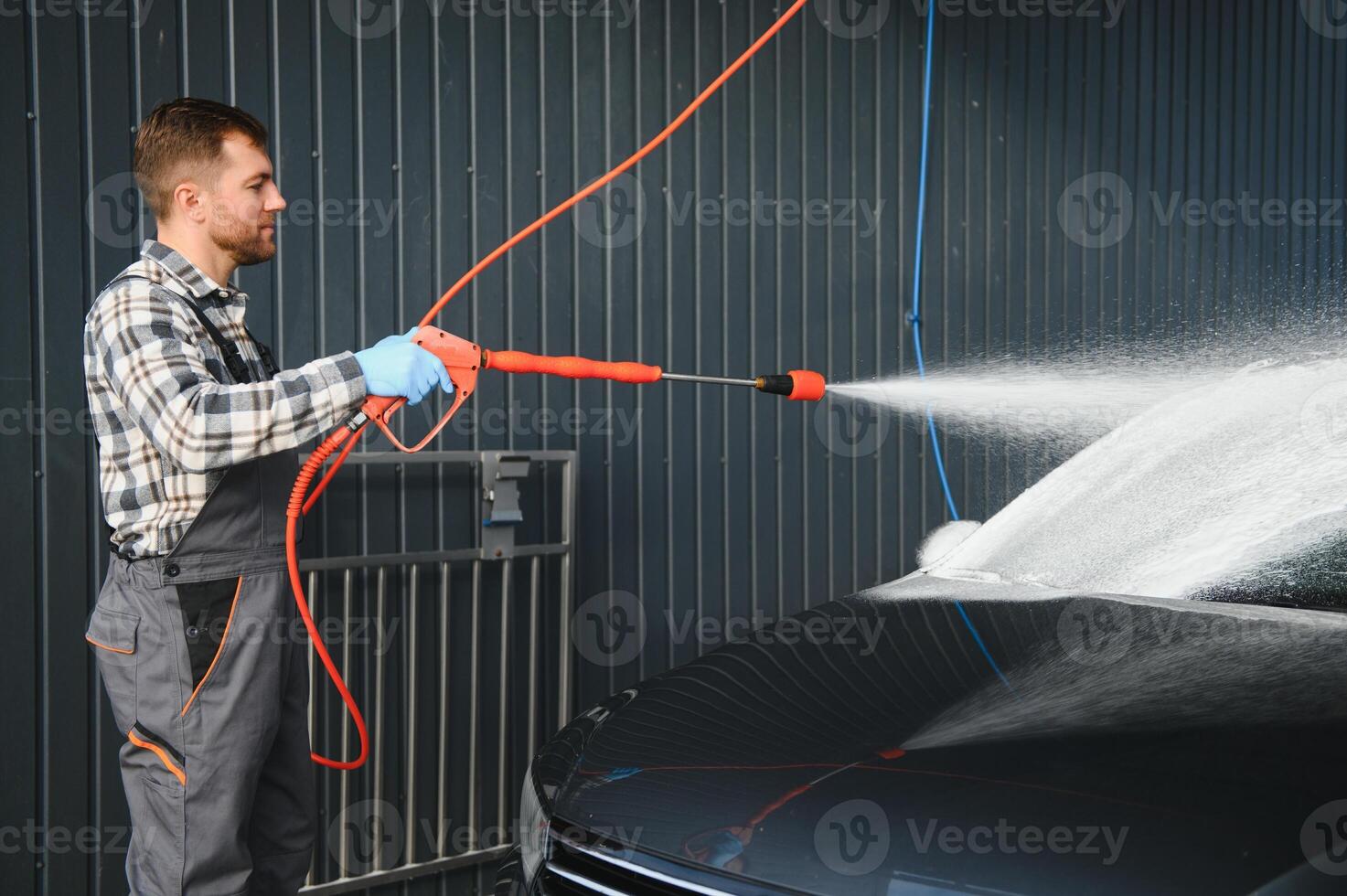 Car Wash Specialist Using Pressure Washer to Rinse a car photo