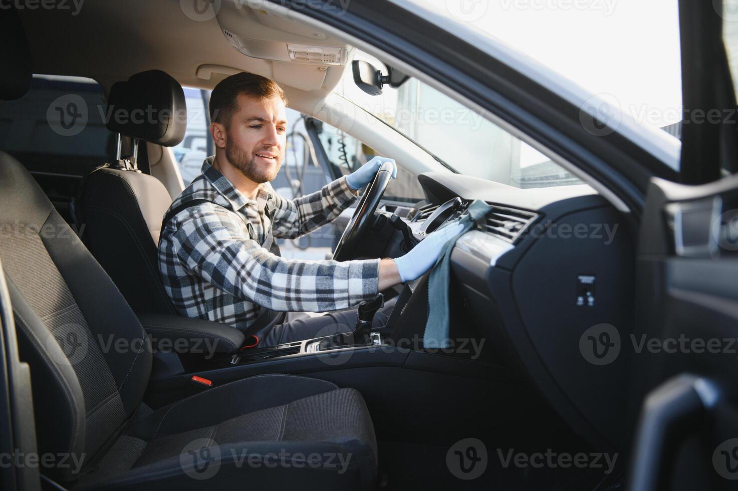 Feeling happy to be doing an excellent job at my job at the car wash. Portrait of a man while sitting inside a customer vehicle photo