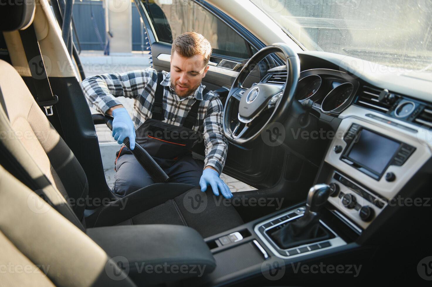 Feeling happy to be doing an excellent job at my job at the car wash. Portrait of a man while sitting inside a customer vehicle photo