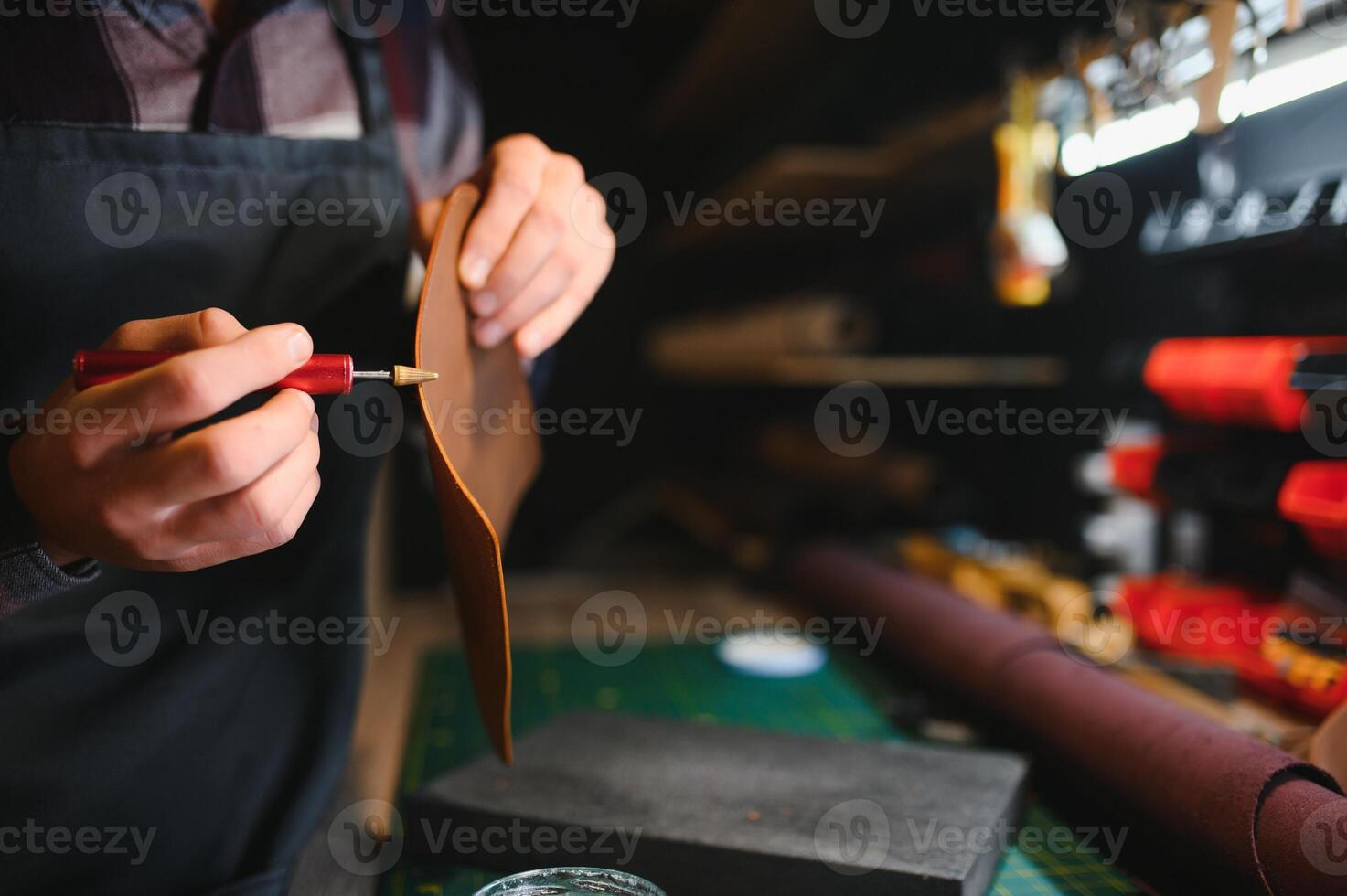 Man working with leather. Professional makes a wallet. photo