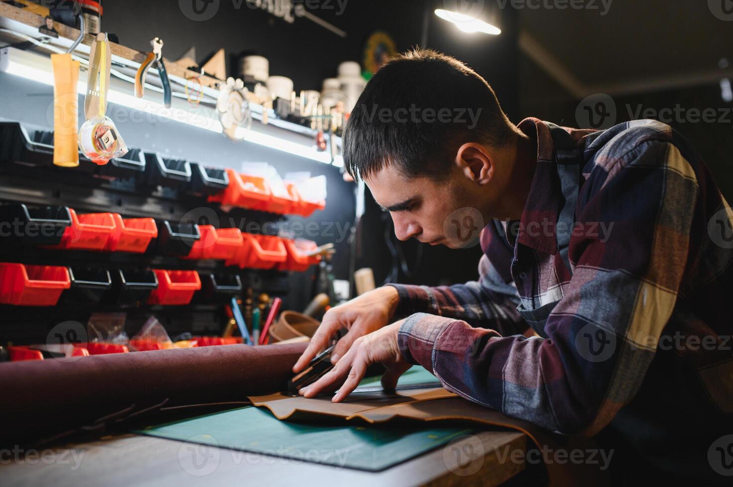 Man working with leather. Professional makes a wallet. photo