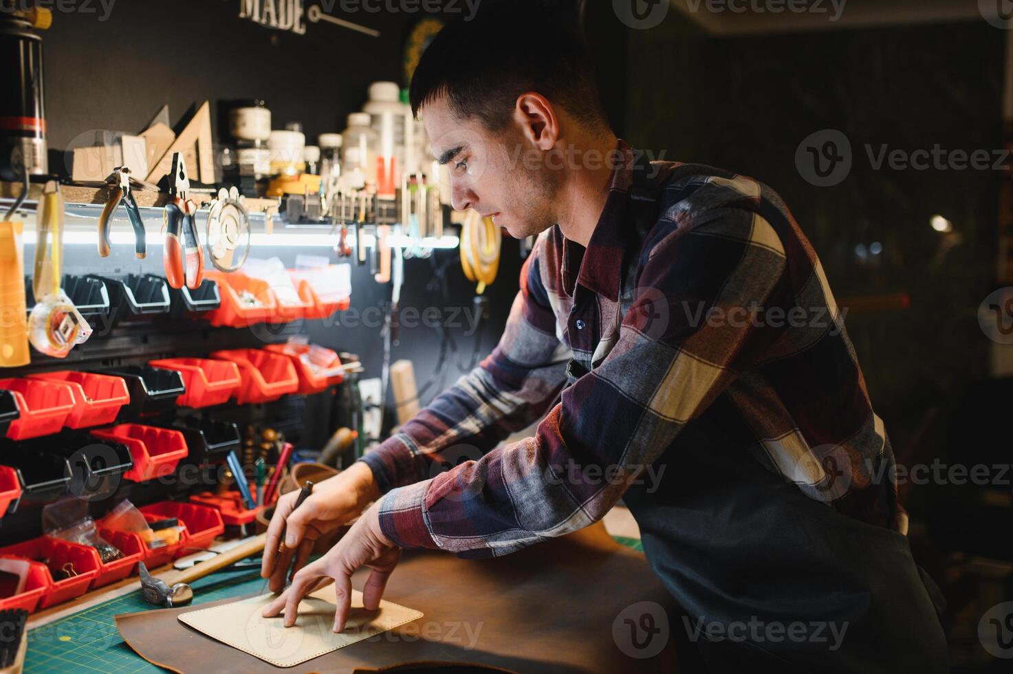 Man working with leather. Professional makes a wallet. photo
