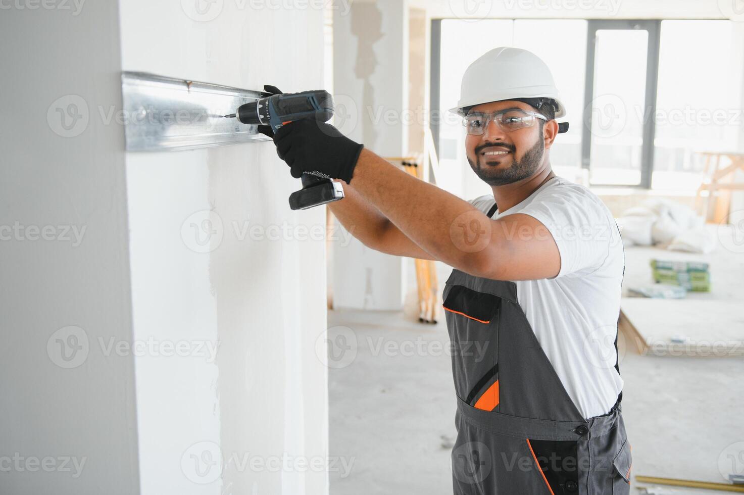man fasten metal profile frame to the wall for draywall bulkhead photo