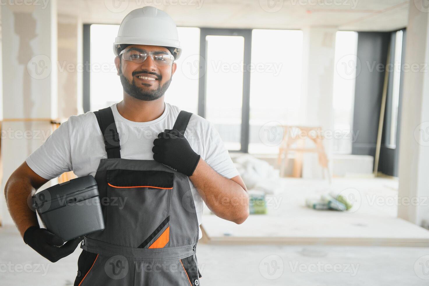 Portrait of young professional Indian worker in uniform and helmet. Construction and repair concept photo