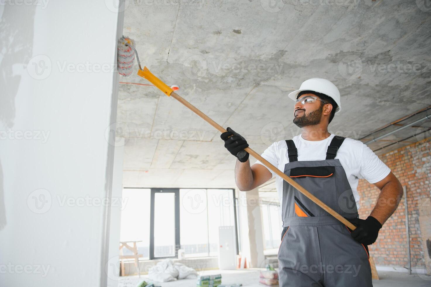 painter doing painting work on wall with roller. concept of hard working, home renovation photo