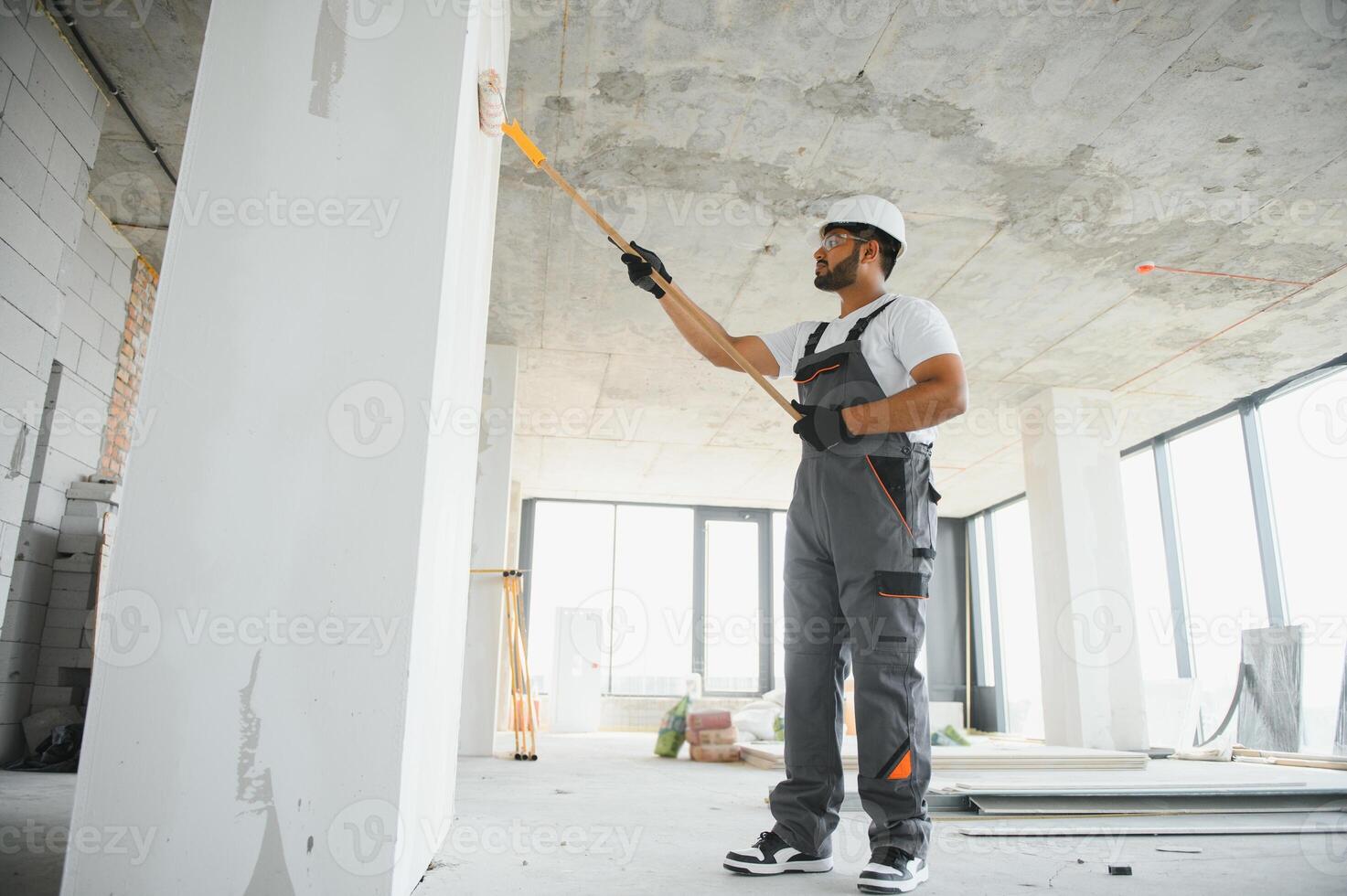 painter doing painting work on wall with roller. concept of hard working, home renovation photo