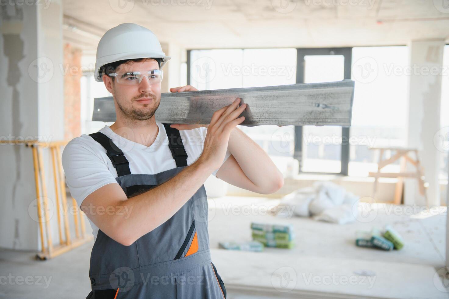 Builder in working uniform cutting metal profile with cutting machine at the construction site indoors photo