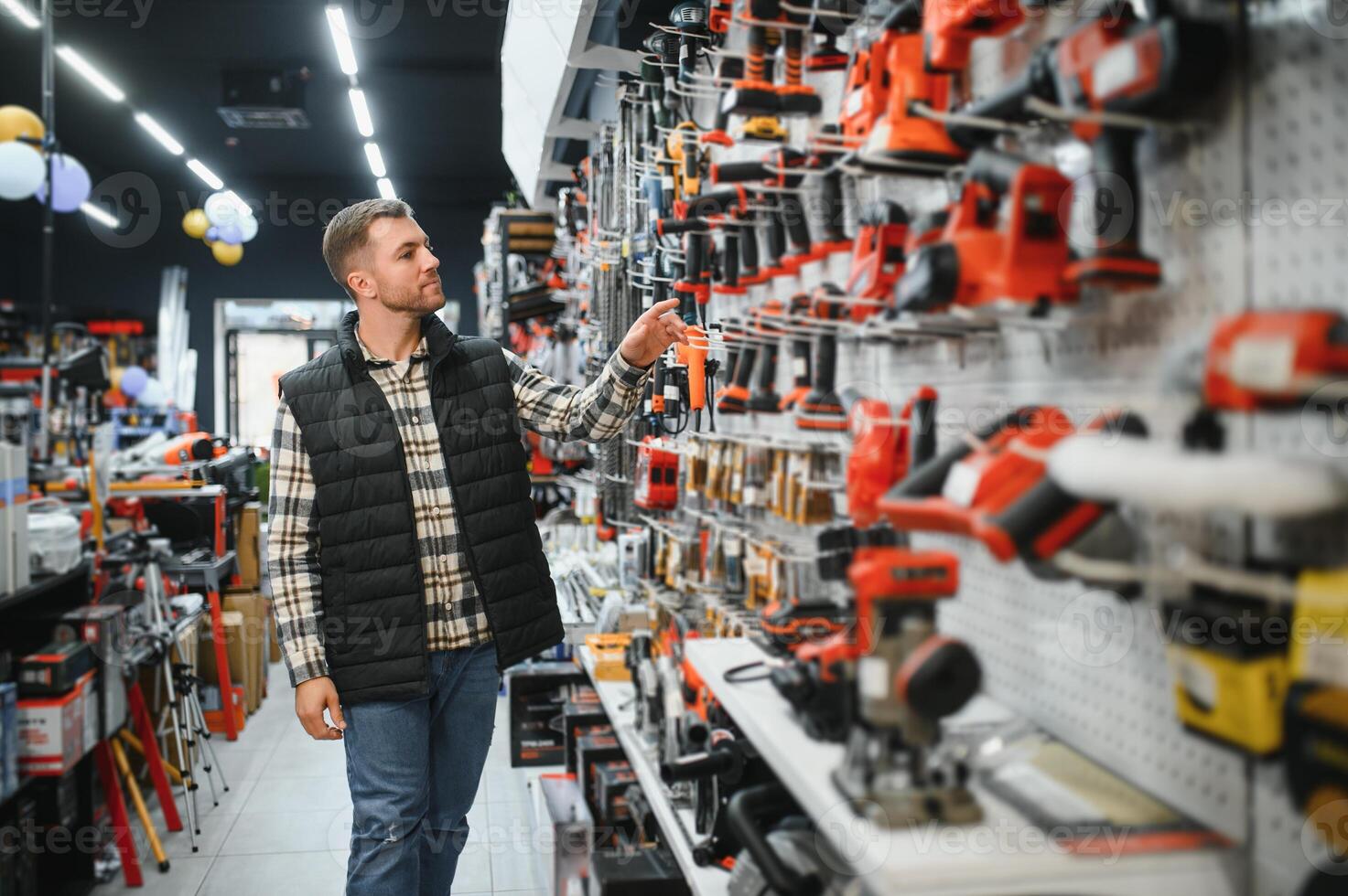 A man chooses a power tool in a hardware store photo