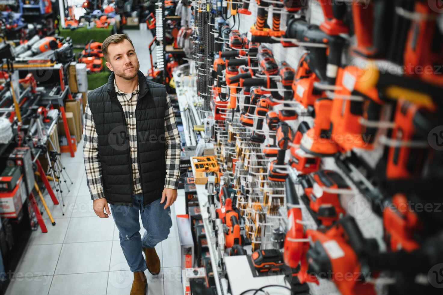 A man chooses a power tool in a hardware store photo