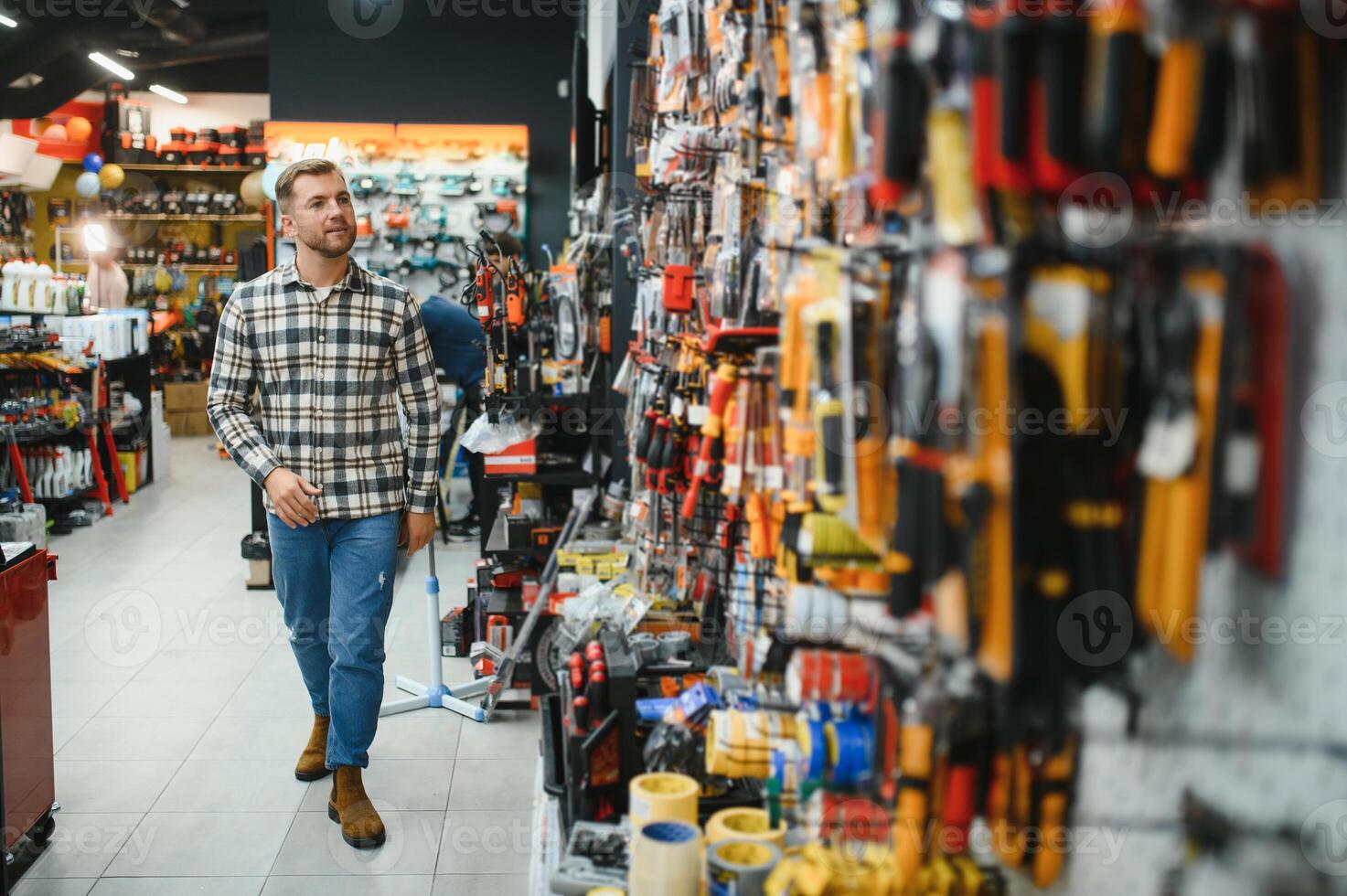 A man in a hardware store choosing a tool photo