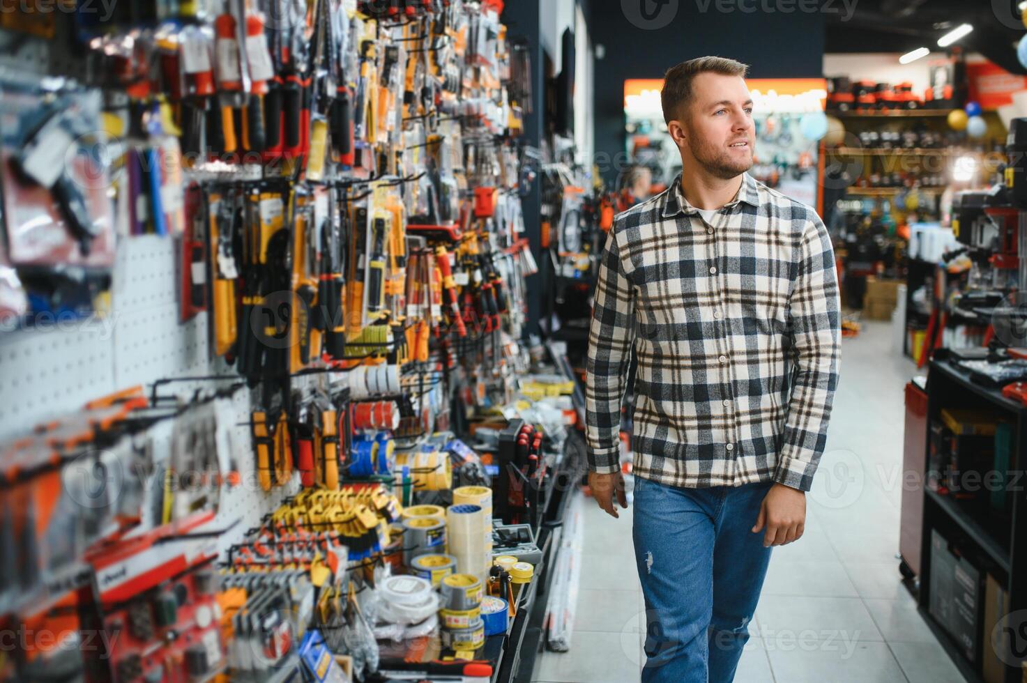 A man in a hardware store choosing a tool photo