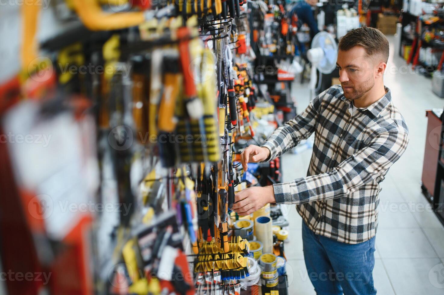 A man in a hardware store choosing a tool photo
