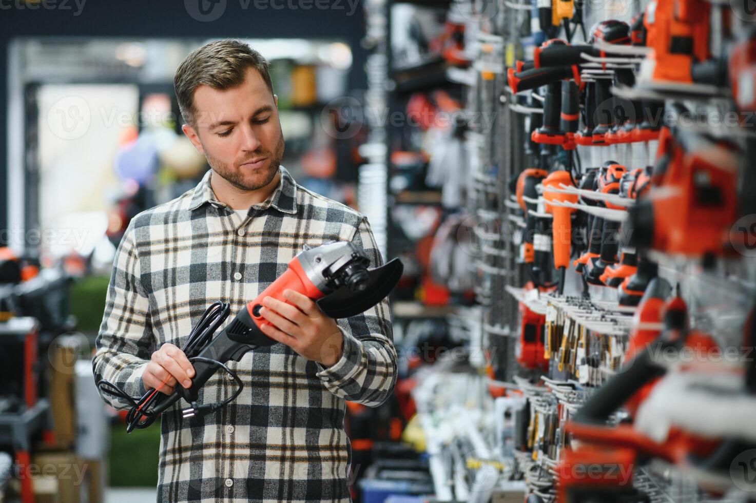 A man chooses a power tool in a hardware store photo