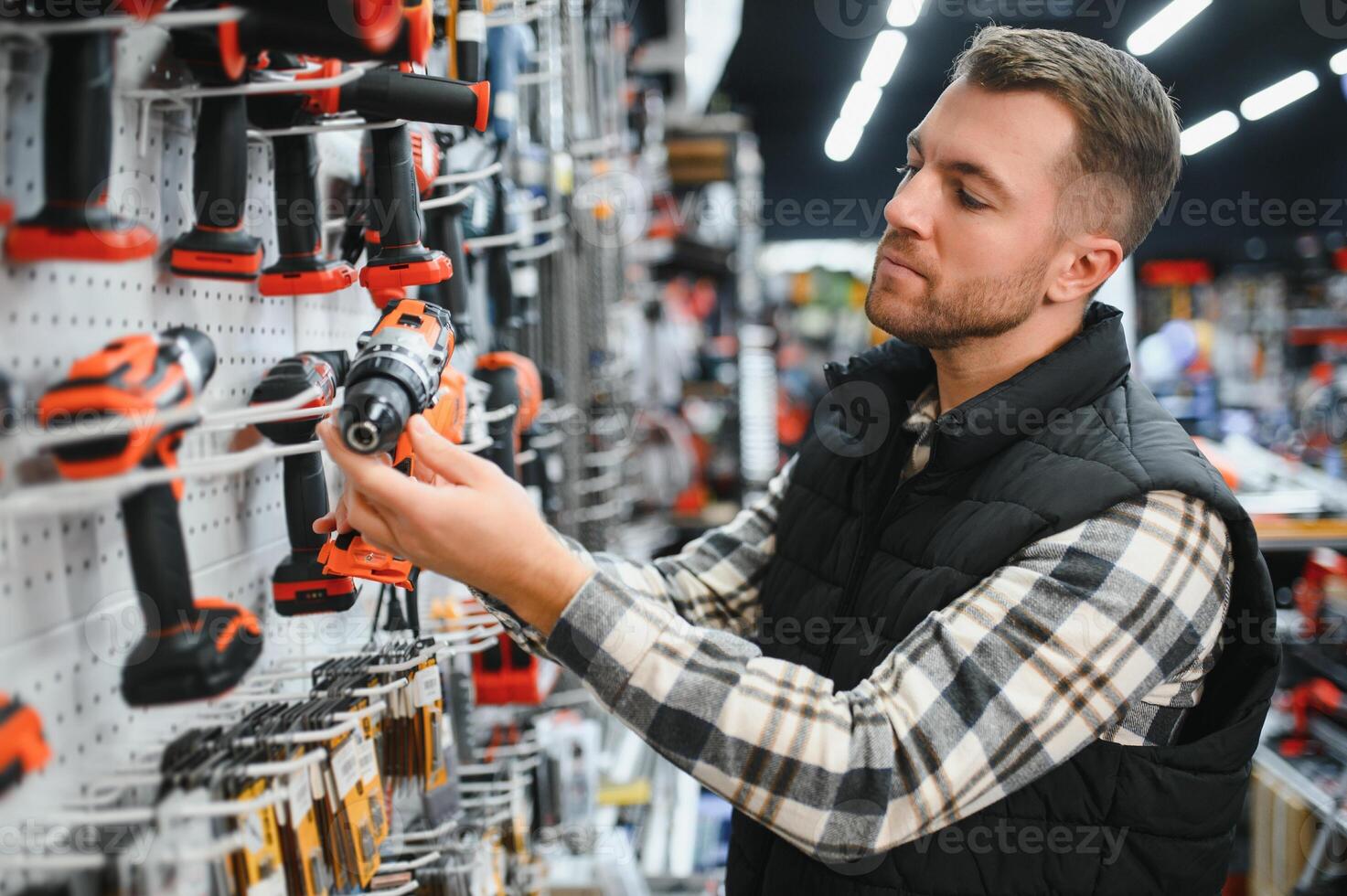 A man chooses a power tool in a hardware store photo