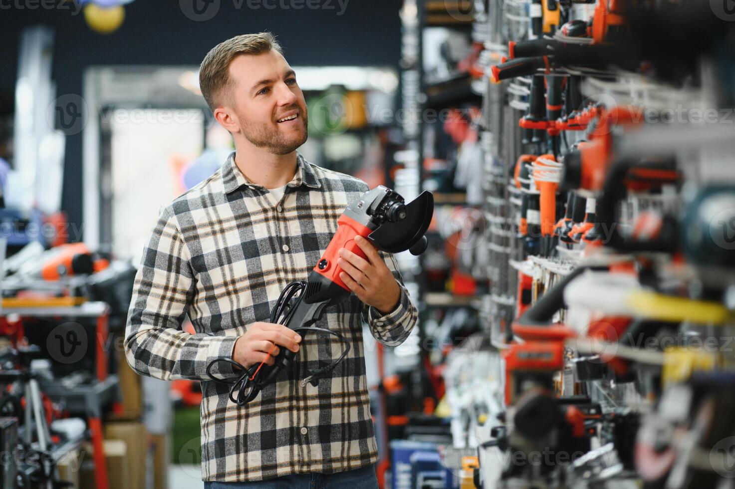A man chooses a power tool in a hardware store photo
