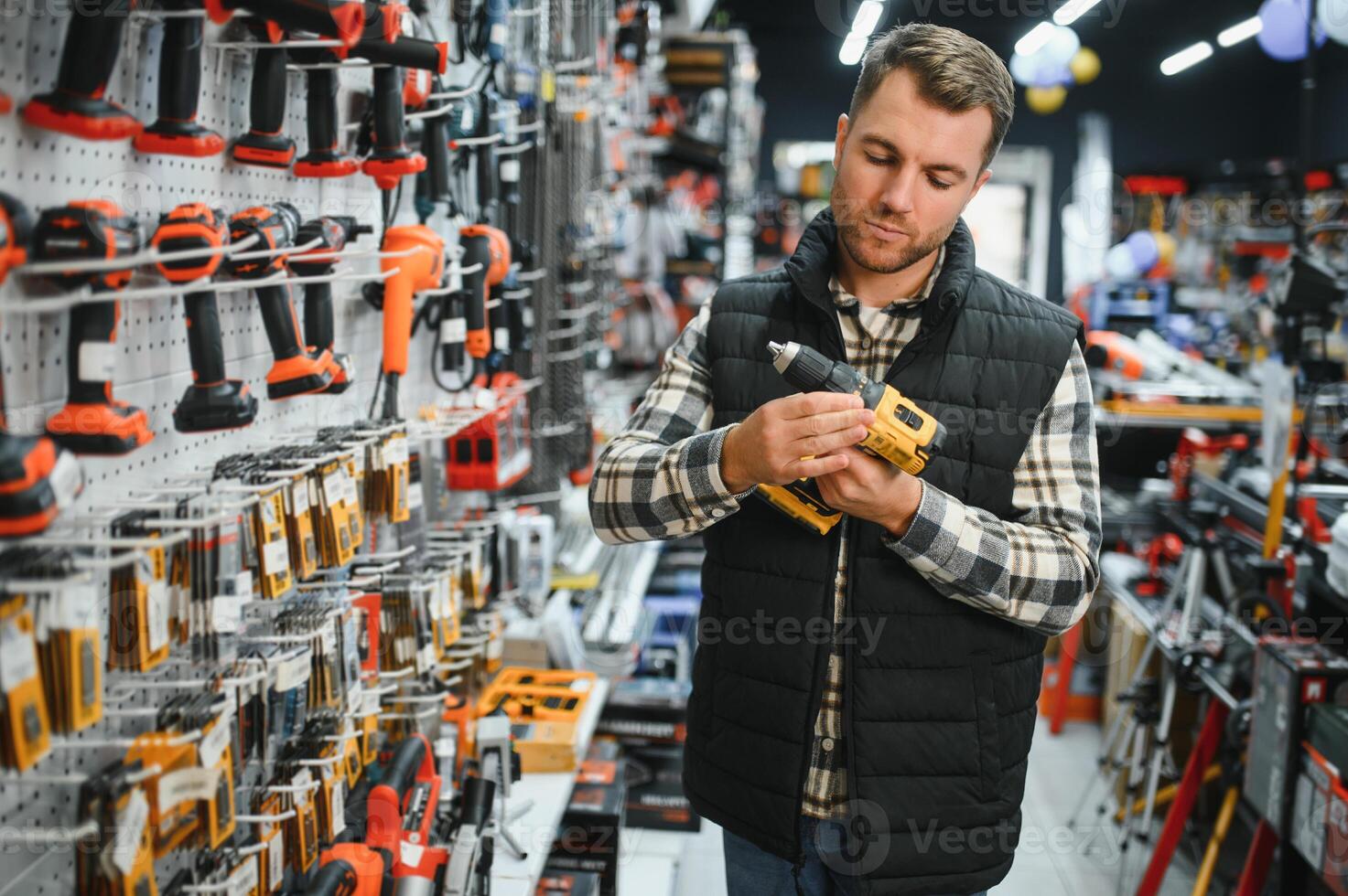 A man chooses a power tool in a hardware store photo