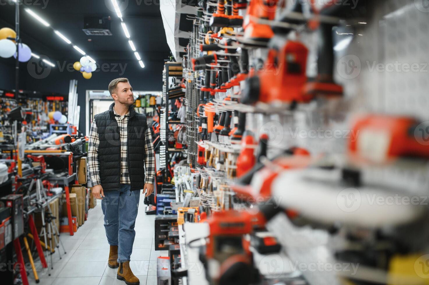 A man chooses a power tool in a hardware store photo