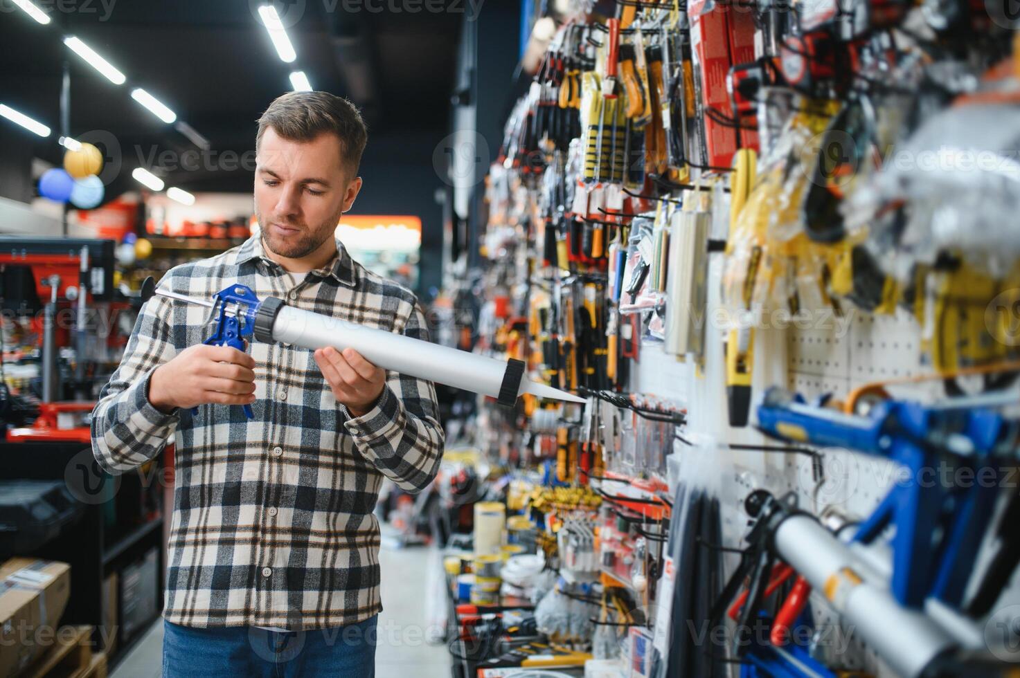 A male buyer in a modern hardware store. A large selection of tools and various household and construction goods photo