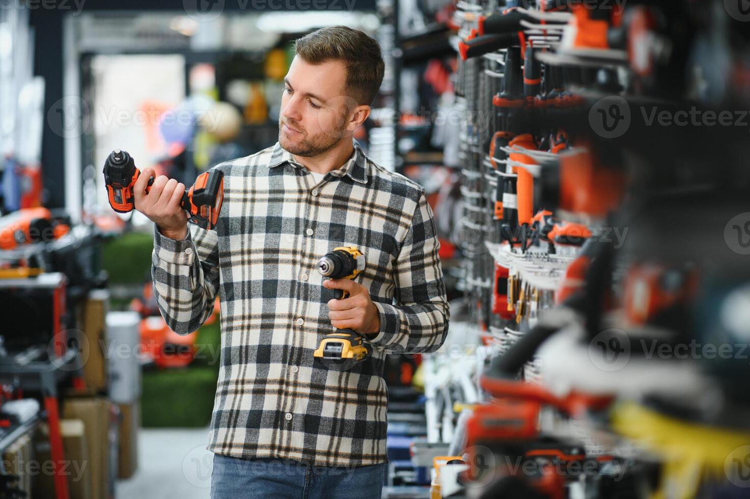 A man chooses a power tool in a hardware store photo