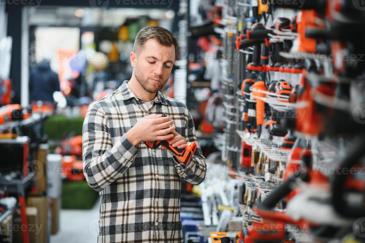 A man chooses a power tool in a hardware store photo