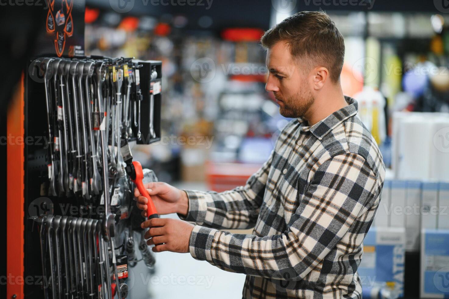 the buyer of the hypermarket of tools and finishing goods chooses an open-end wrench photo