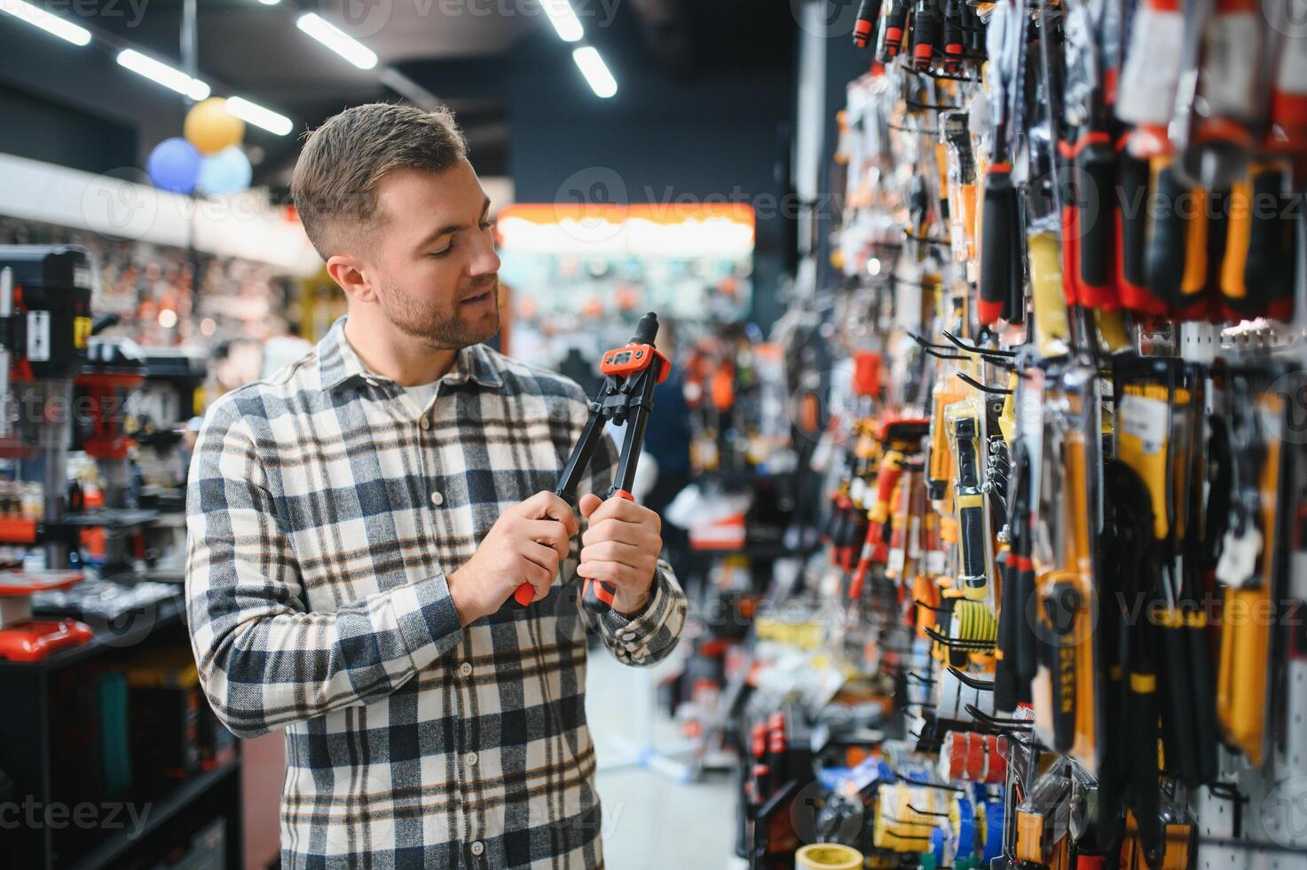 A man in a hardware store choosing a tool photo
