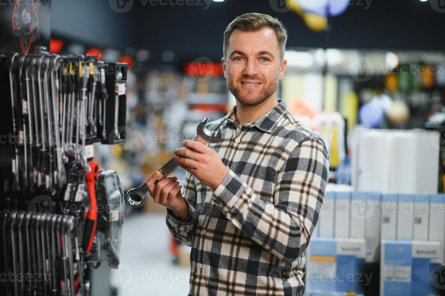 A man in a hardware store choosing a tool photo