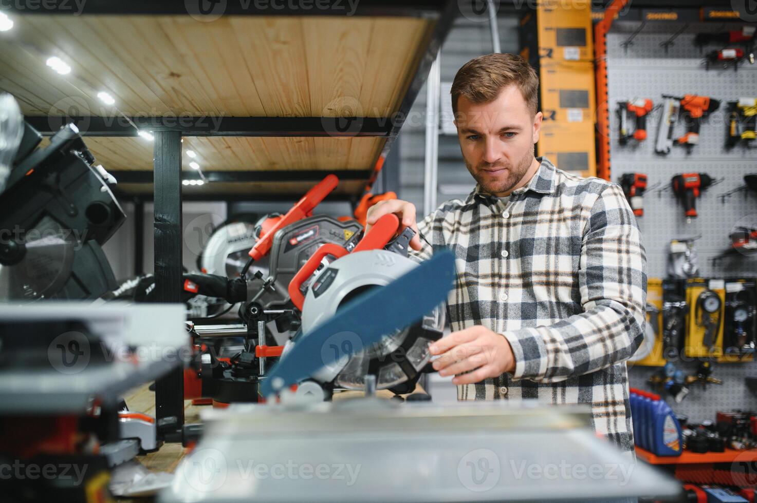 A male buyer chooses power tools in a hardware store. A large selection of tools photo