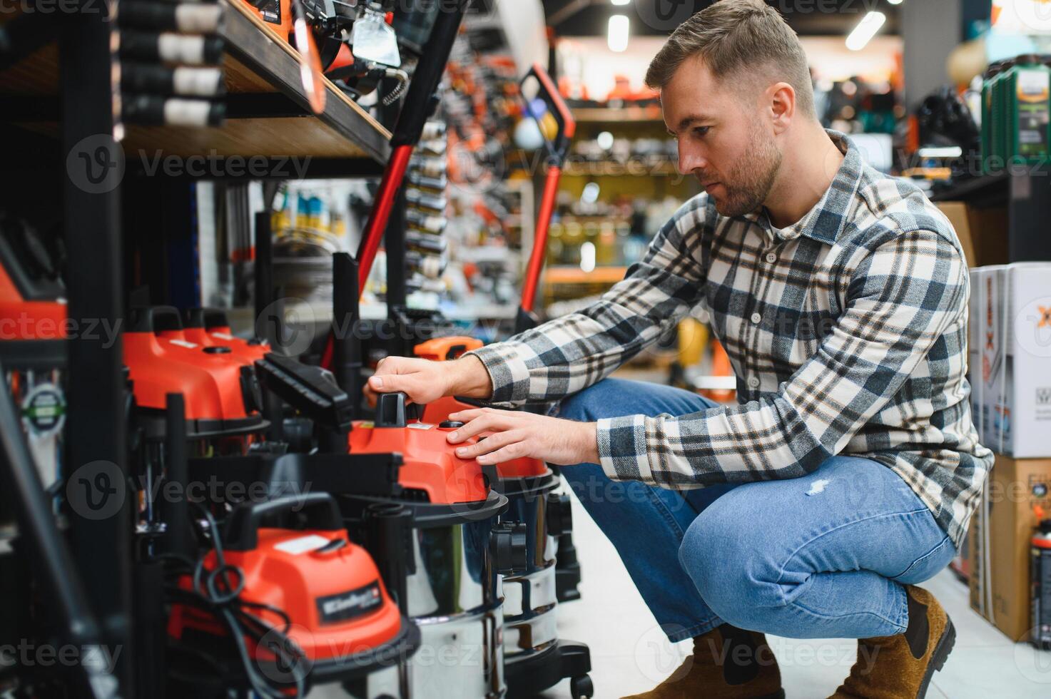 A man in a hardware store choosing a tool photo