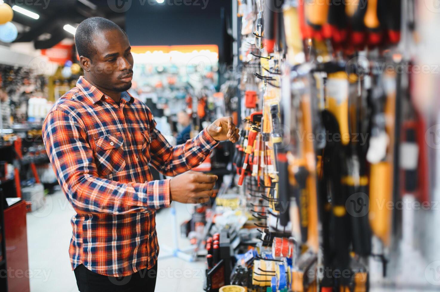 An African American man chooses tools in a hardware store photo