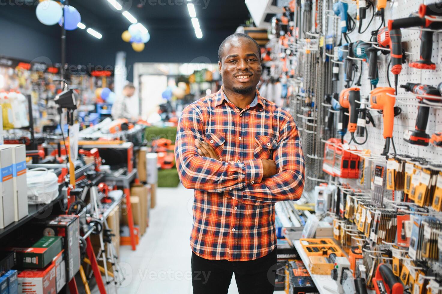 A african american man chooses a power tool in a hardware store photo