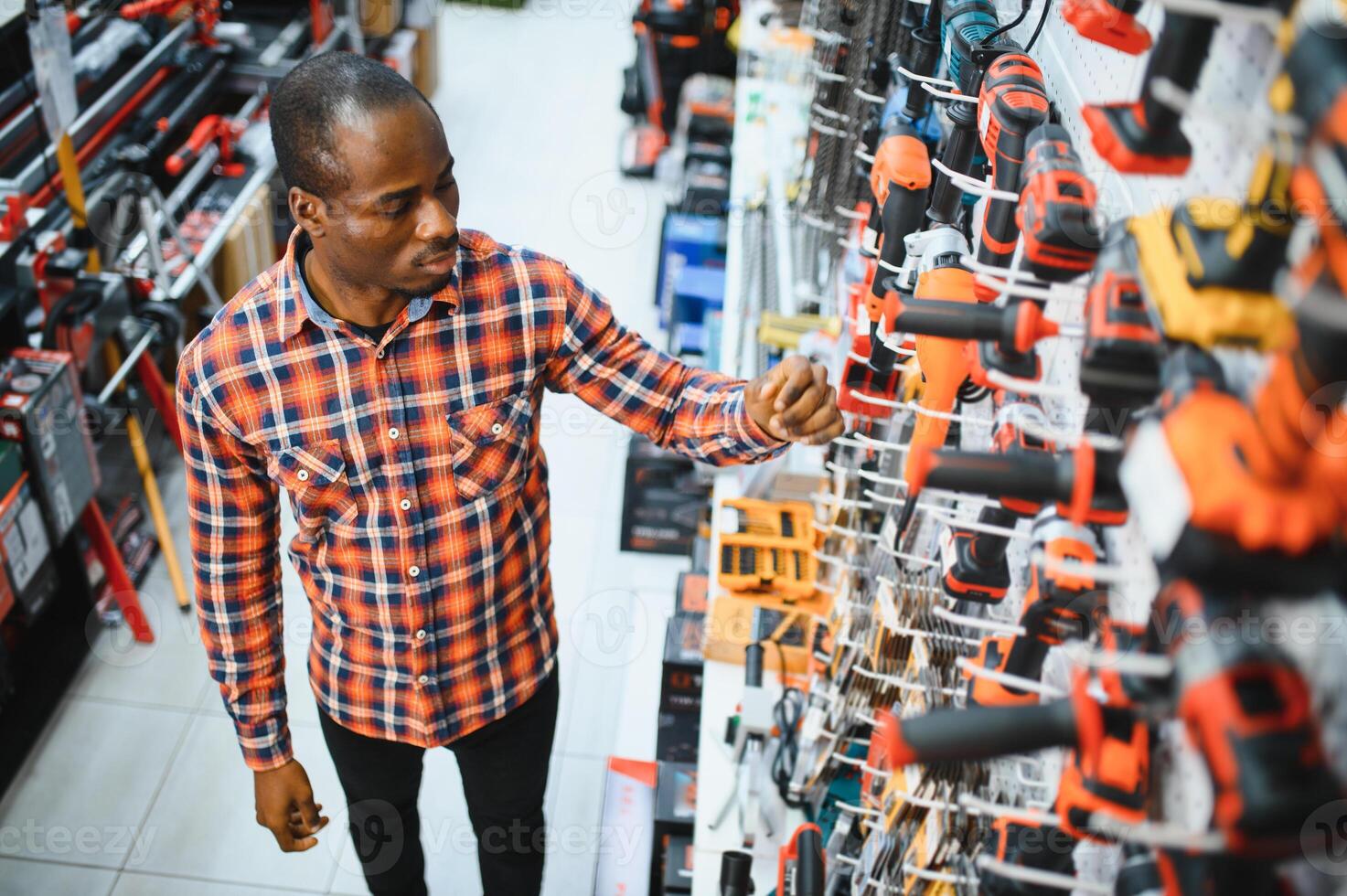 A african american man chooses a power tool in a hardware store photo