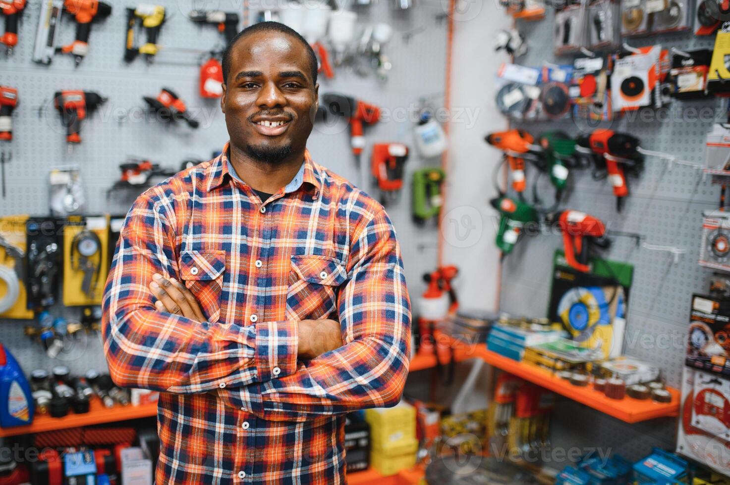 African americam man buying modern electric drill while standing in tool. Hardware construction site objects concept photo