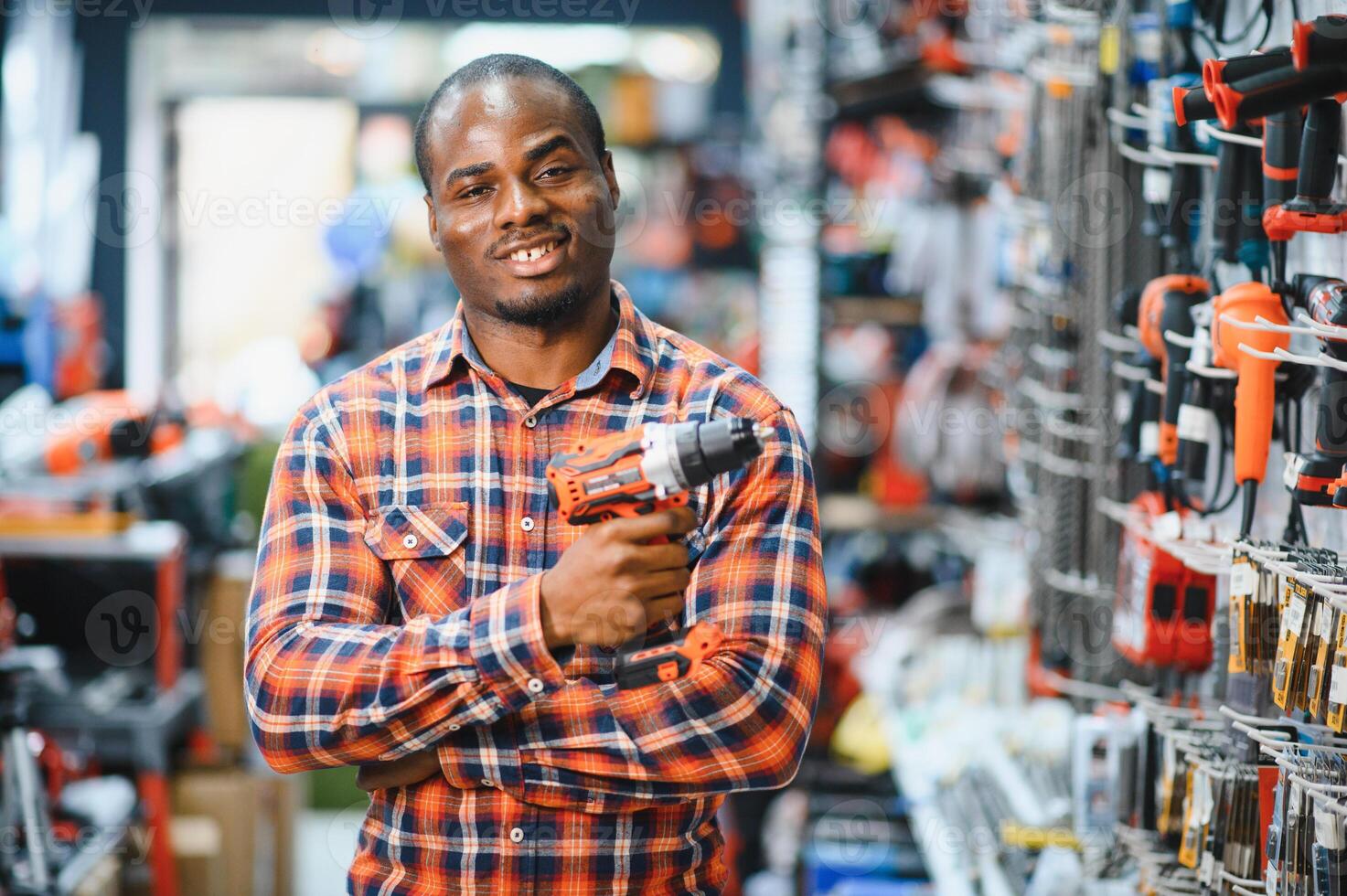 A african american man chooses a power tool in a hardware store photo