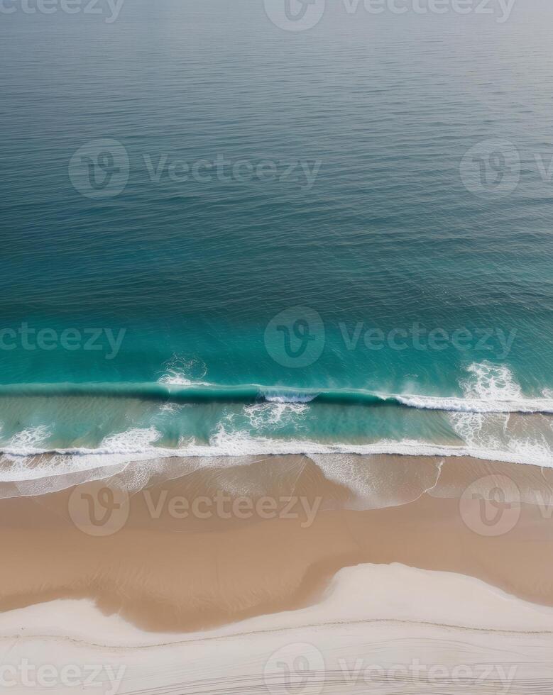 Aerial view of turquoise ocean waves crashing on sandy beach photo