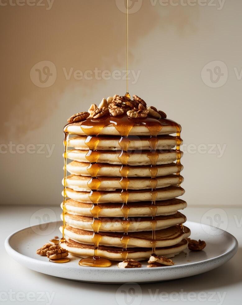 Deliciously stacked pancakes with syrup and nuts on a plate photo