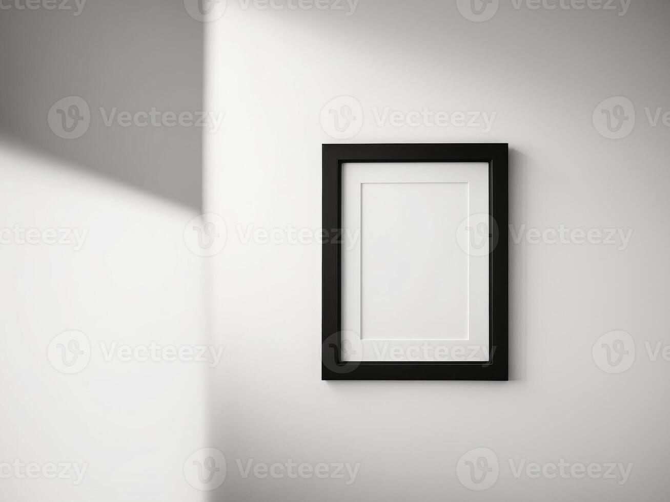 A white wall with a black frame and a white picture hanging on it. photo