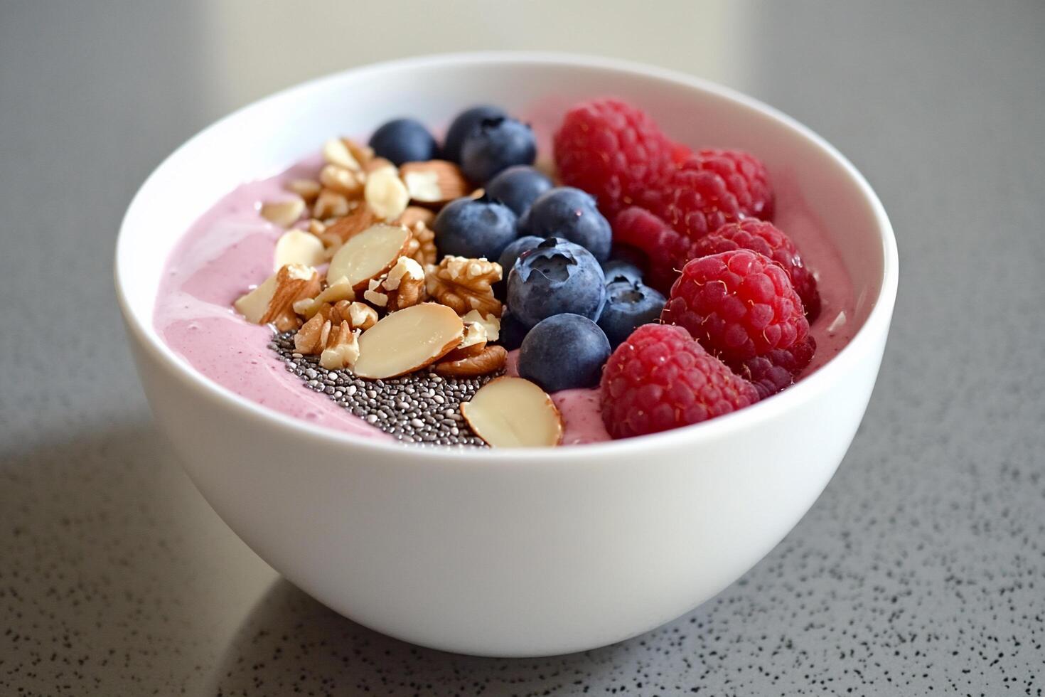A smoothie bowl topped with berries, granola, and chia seeds. photo