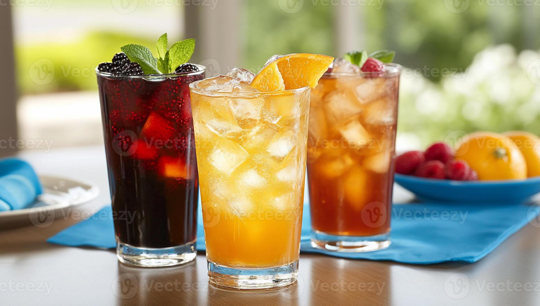 Three refreshing drinks with ice, garnished with fruit and mint. photo