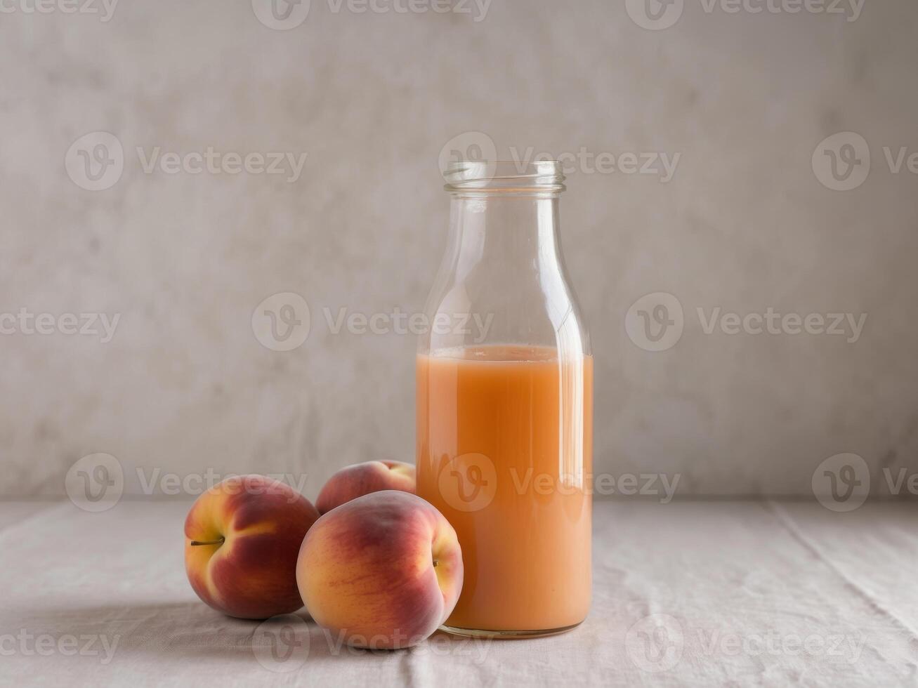 A bottle of peach juice next to a bunch of peaches. photo