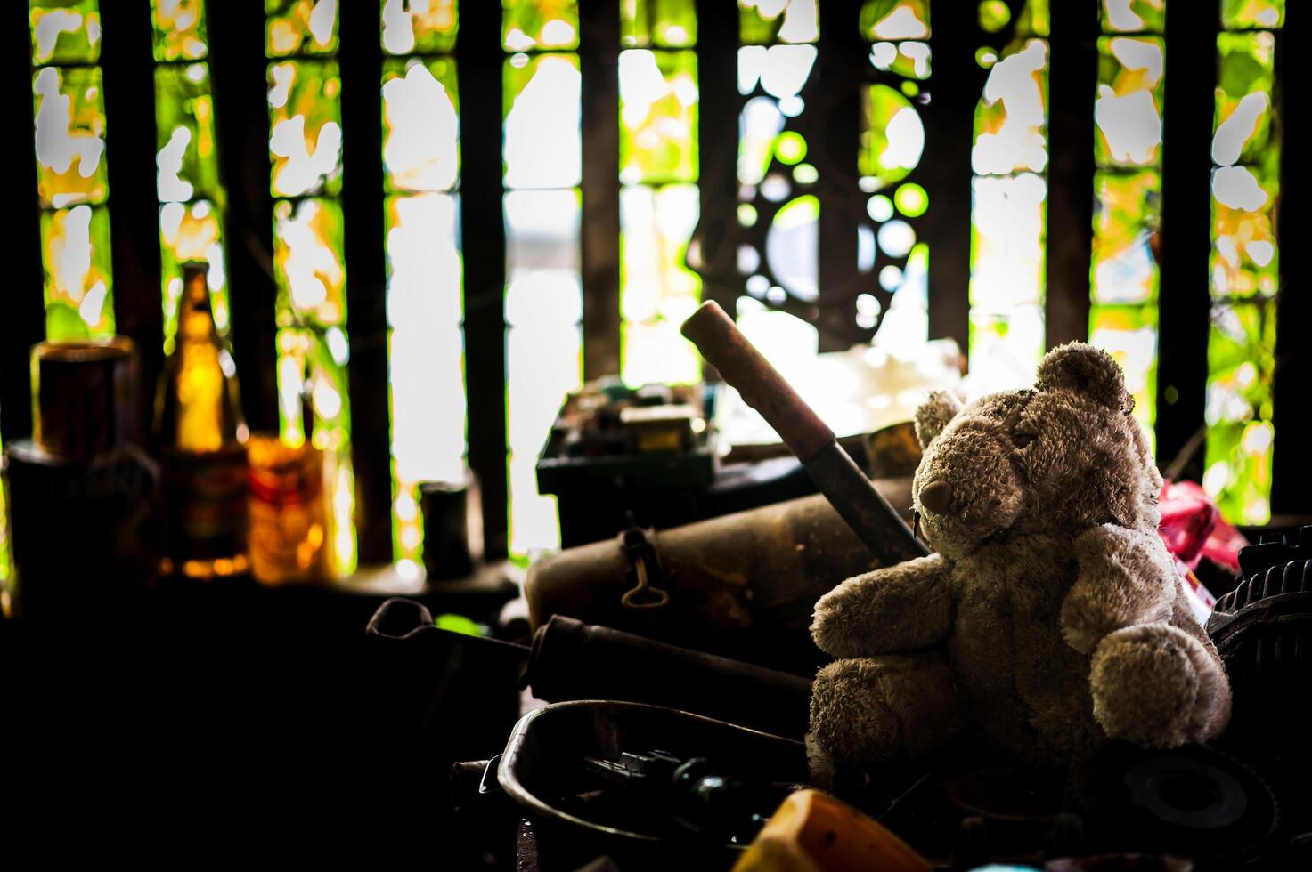 Bear doll with Old tool in dirty place photo