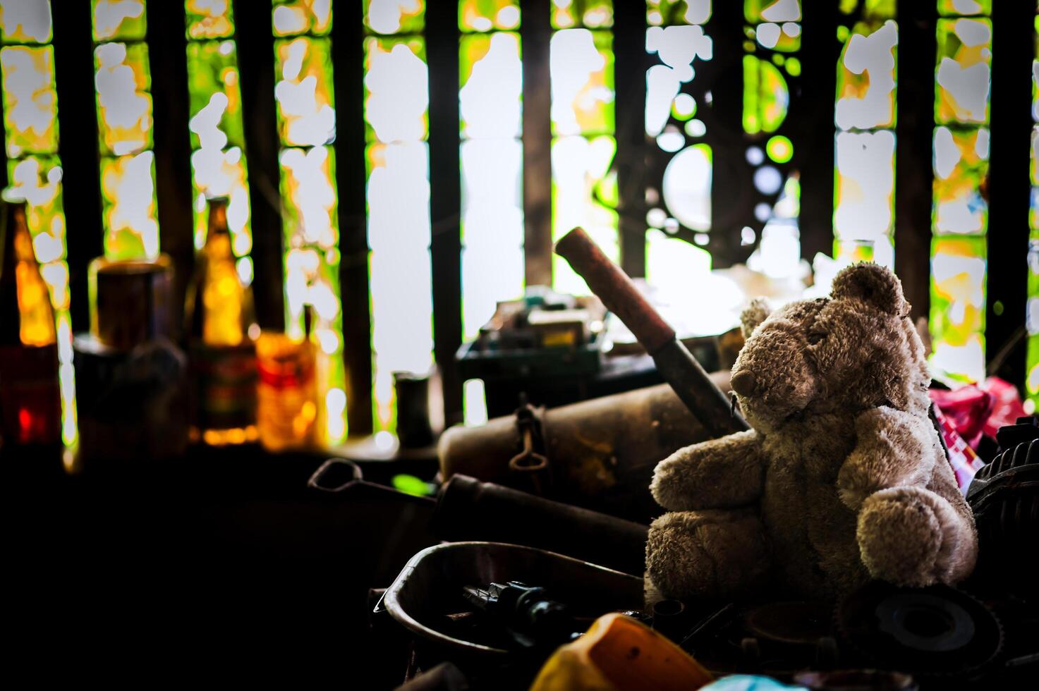 Bear doll with Old tool in dirty place photo