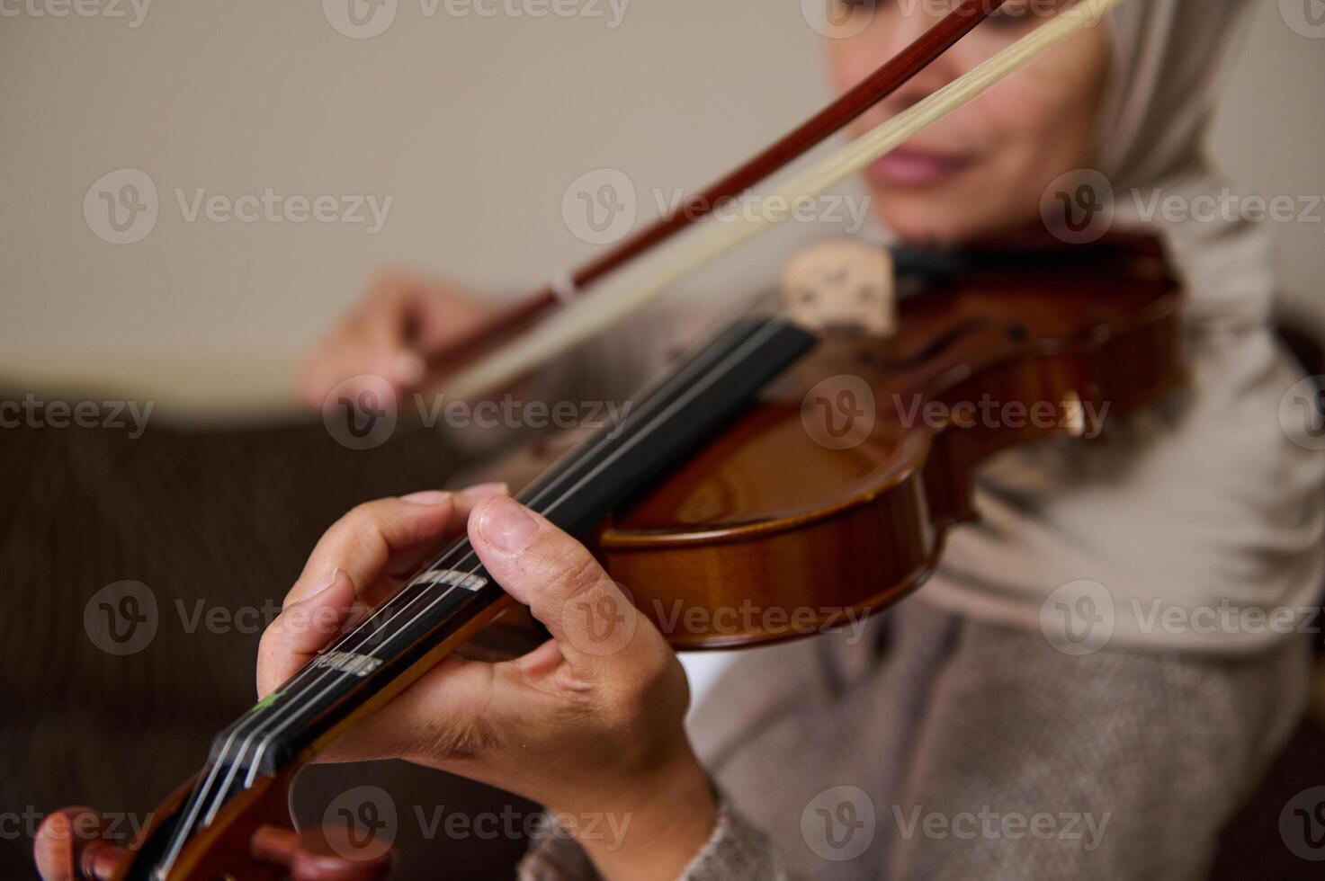 Close-up of woman playing violin with focus on hands and instrument photo