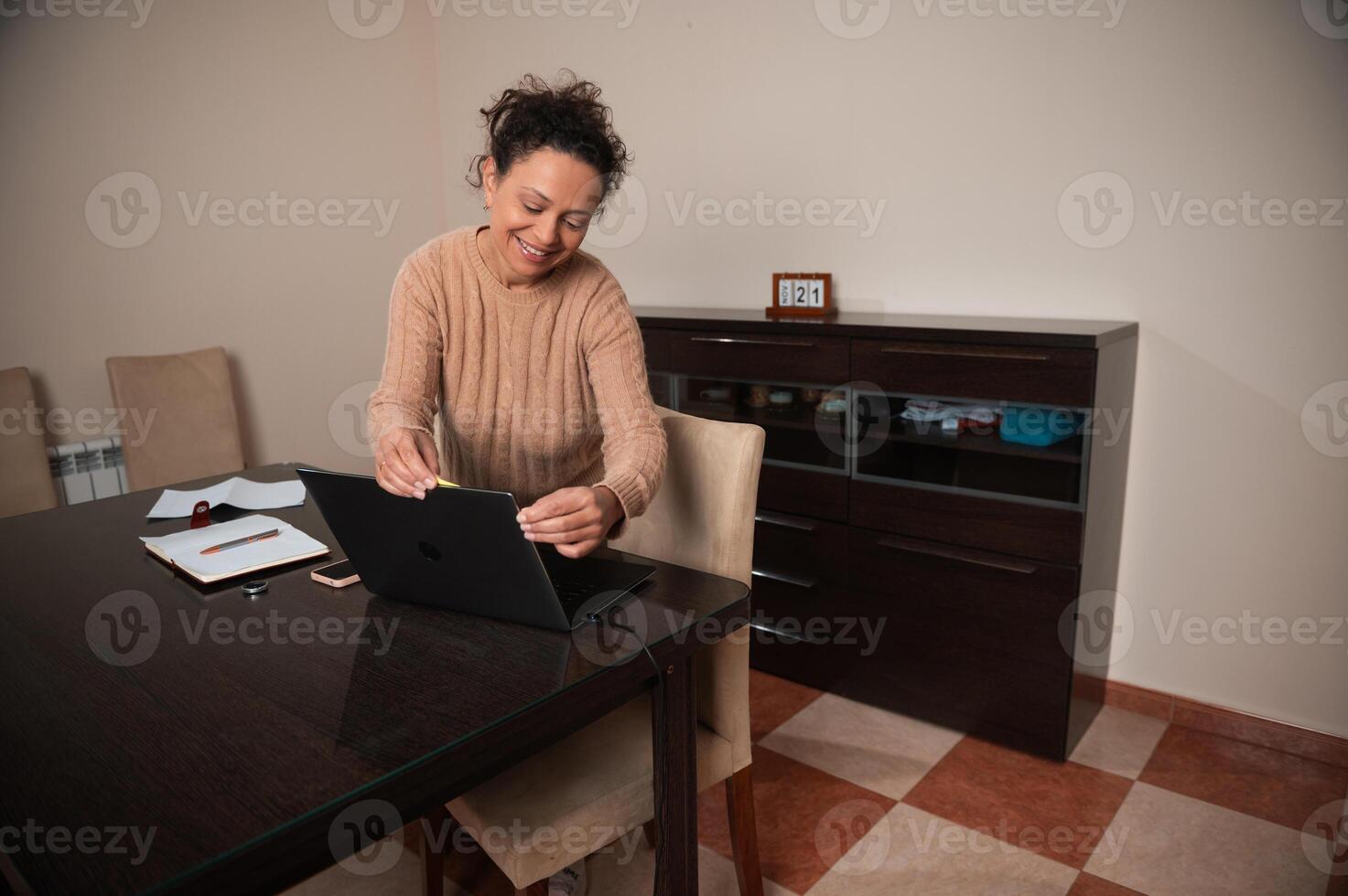 Woman happily working from home at a laptop in cozy environment photo